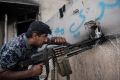 An Iraqi federal policeman fires a machine gun at an Islamic State position during the battle to recapture west Mosul.