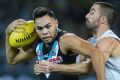 Port's Jarman Impey is tackled by Kade Simpson of the Blues at Adelaide Oval on Friday night.