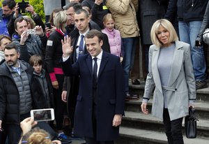 Centrist candidate Emmanuel Macron and his wife Brigitte leave after casting their vote in the first round of the French presidential election, in le Touquet, northern France, Sunday April 23, 2017.