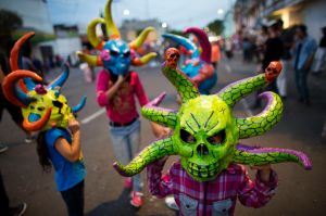 Little girls wear masks during a neighborhood celebration of "the burning of Judas," in central Mexico City, Saturday, ...