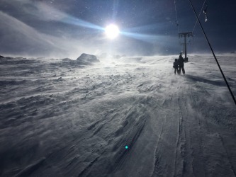 Thredbo ski lift on a windy day looking into the sun.