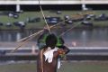 An indigenous man aims his arrow at police during a protest in favor of the demarcation of indigenous lands outside the ...