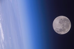 File - Framed by the Earth's horizon and airglow, the full moon floats in the blackness of space in this photo from the Expedition 10 crew on board the International Space Station.