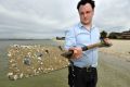 Michael Bourke with sand at Middle Park beach. Each grain of sand would host hundreds of micro-algae.  