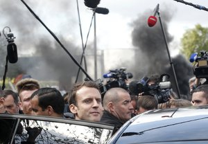 French centrist presidential election candidate Emmanuel Macron,center, leaves the Whirlpool home appliance factory Wednesday April 26, 2017 in Amiens, northern France.