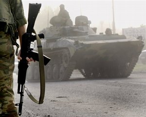 A Russian military vehicle maneuvers on the road while a convoy with troops drives towards the Abkhazian border after leaving the Georgian army base of Senaki, western Georgia, Saturday, Aug. 23, 2008. Russia started to withdraw its forces from Georgia on Friday, promising that the pull out will be accomplished in a day, but Russian troops started to dig new positions around the Black Sea port of Poti, which is 32 km (20 miles) south of Abkhazia and lies well outside the security zone, where Russian peacekeeping forces are allowed to stay on Geor