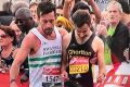 Matthew Rees, left, helps David Wyeth in the final stages of the London Marathon.