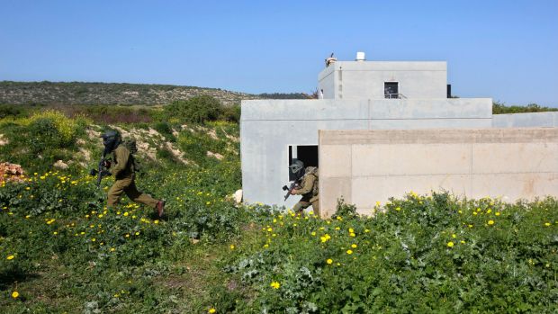 Israeli soldiers train with paintball guns during a drill at an Army base near Elyakim, Israel, as Israeli officers ...