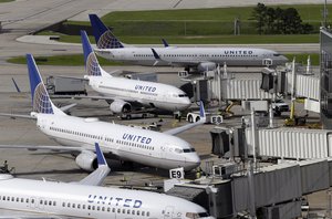 In this July 8, 2015, file photo, United Airlines planes are parked at their gates as another plane, top, taxis past them at George Bush Intercontinental Airport in Houston.