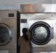 An employee closes a door of an industrial washing machine at the Guangzhou Lijing Washing Machine Company Ltd. factory ...