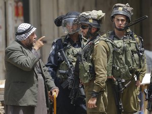 A Palestinian argues with Israeli soldier during clashes after a protest, in solidarity with Palestinian prisoners on hunger strike in Israeli jails, in the West Bank city of Hebron, Thursday, April 27, 2017.