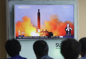 File - People watch TV news shows an image of North Korea's ballistic missile.