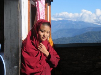 Student nun at the Kila Gompa nunnery in Bhutan.   The Buddhist  nunnery is situated on a cliff side high above the Paro ...