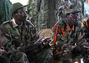 In this Nov. 12, 2006 file photo the leader of the Lord's Resistance Army, Joseph Kony, left, and his deputy Vincent Otti sit inside a tent at Ri-Kwamba in Southern Sudan.