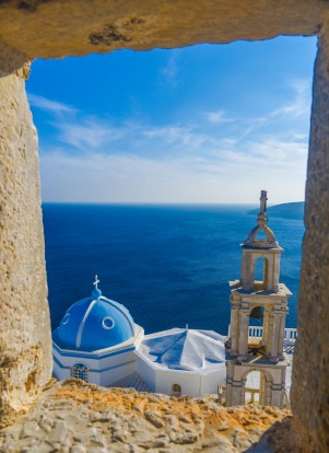 Panagia Portaitissa monastery viewed from a window of Querini's Venetian Castle, Astypalea Island, Greece.After taking ...