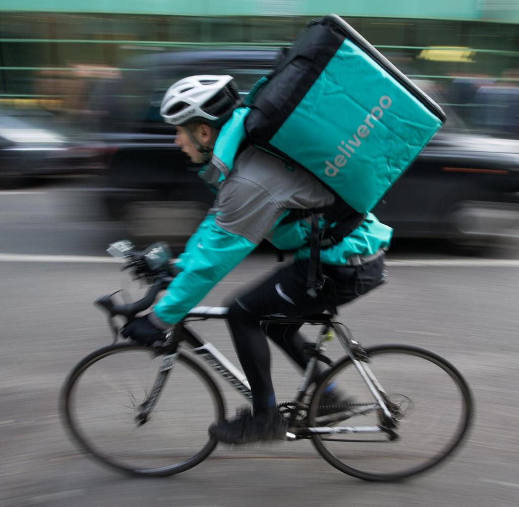 Restaurant Food Delivery company 'Deliveroo' employee, Billy Shannon at work in Camden Town, north London in November 17, 2016. Lunch hour has just started in the north London borough of Camden, which means it's crunch time for Billy Shannon, a fresh-faced food-delivery courier. Dressed in thermal clothing to ward off the autumnal cold, the 18-year-old jumps on his bike as an order comes in, mindful that he is paid not by the hour, but by the number of deliveries he makes. / AFP / DANIEL LEAL-OLIVAS (Photo credit should read DANIEL LEAL-OLIVAS/AFP/Getty Images) Getty ImagesGetty Images