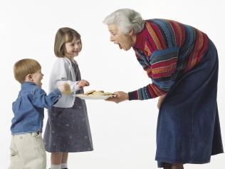 Caucasian young kids get cookies from grandma and giggle. Children. Grandmother. Generic image. Thinkstock.