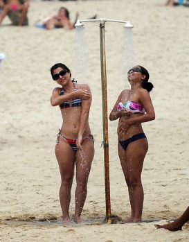 Women take a shower at Ipanema beach.