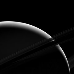 File - Although only a sliver of Saturn's sunlit face is visible in this view, the mighty gas giant planet still dominates the view.