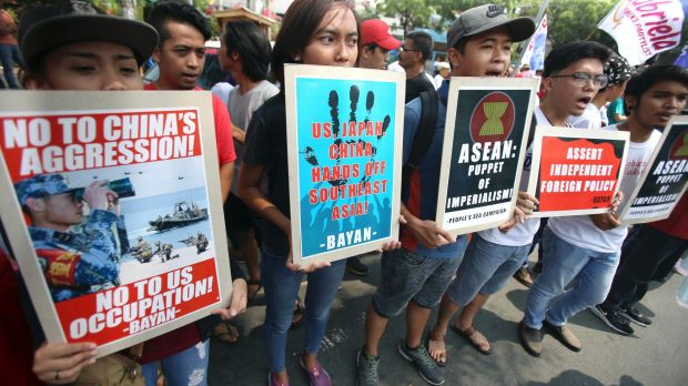 Protesters display placards at a rally near the venue in Manila.