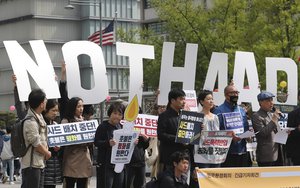 In this Friday, April 28, 2017, photo, South Koreans hold letters reading "NO THAAD" during a rally to oppose a plan to deploy an advanced U.S. missile defense system called Terminal High-Altitude Area Defense, or THAAD, near the U.S. Embassy in Seoul, South Korea.