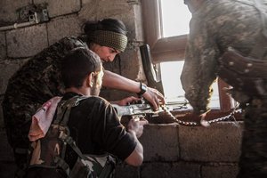 YPG and YPJ fighters reload a machine gun during the Raqqa offensive, Syria