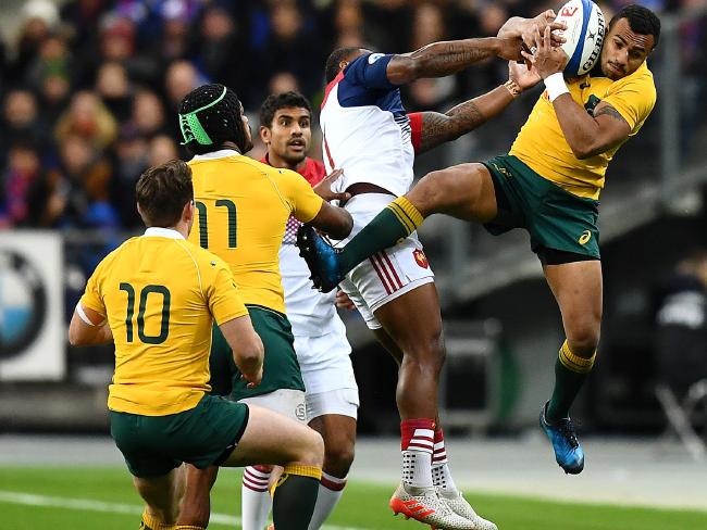 Australia's scrum half Will Genia (R) grabs the ball from France's right wing Noa Nakaitaci (C).