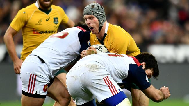 David Pocock carries the ball into a tackle by Camille Chat and Kevin Gourdon of France.