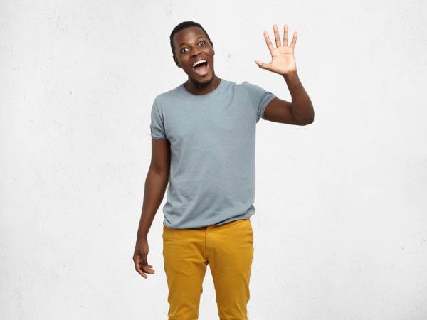 A man holding up his hand with 5 fingers raised.