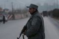 A member of the Afghan security forces stands guard near the site of two blasts in Kabul on Tuesday. 