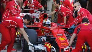 Ferrari mechanics push the car of driver Sebastian Vettel of Germany tin the pit lane during the qualifying session ...