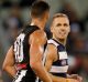 Scott Pendlebury and Joel Selwood exchange words.