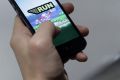 A man plays Nintendo Co.'s Super Mario Run mobile game on an Apple Inc. iPhone in this arranged photograph in Tokyo, ...