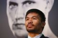 He's behind you: Manny Pacquiao speaks to the media as a picture of Jeff Horn looms over him.