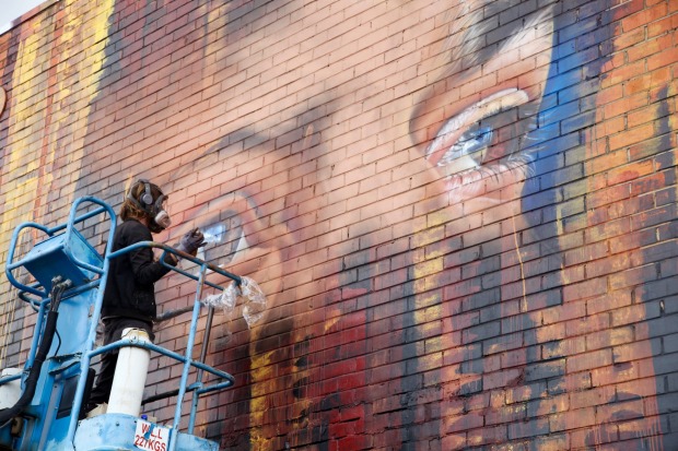 Adnate starts on his portrait of an Indigenous Australian man.