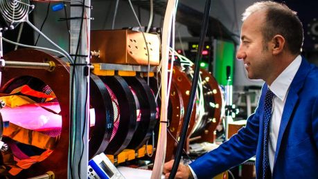 Director of the Australian Plasma Fusion Research Facility at ANU Dr Cormac Corr with the glowing MAGPIE II - a machine ...