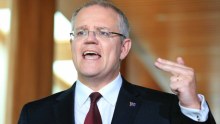 Scott Morrison gestures with his left hand and two fingers during a press conference