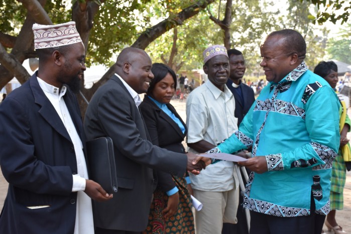 Chief Secretary to the Government of Malawi, Mr. George Mkondiwa hands  over a Code of Conduct to members of Mangochi District Peace Committee (DPC) at the launch of the DPC in Mangochi