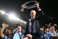 Graham Arnold is hoisted by players with the A-League trophy.