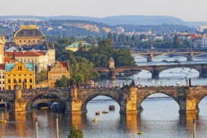 The Vltava River bridges shine in the setting sun.