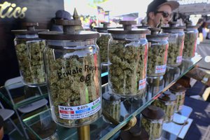 In this Sunday, April 23, 2017 photo large jars of marijuana are on display for sale at the Cali Gold Genetics booth during the High Times Cannabis Cup in San Bernardino, Calif.