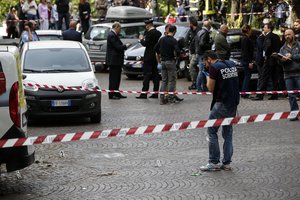 Italian policeman inspect the site where an explosive device blasted off near a post office in Rome, Friday, May 12, 2017.