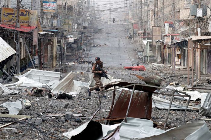 An Iraqi special forces soldier runs across a street during a battle with Islamic State militants in Mosul