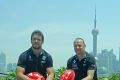 Port Adelaide captain Travis Boak and head coach Ken Hinkley in front of the Pudong skyline in Shanghai.