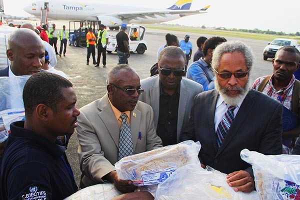 Le Ministre Carmel André Belliard (au milieu) entrain d'inspecter les semences en présence du Directeur des Opérations du PNUD, Safiou Esso Ouro-Doni (Dérrière) 