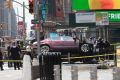 A car rests on a security barrier in New York's Times Square after driving through a crowd of pedestrians.