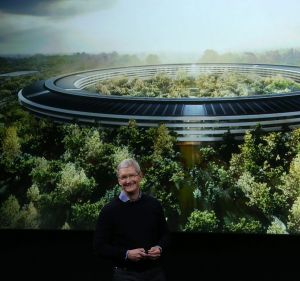 Apple CEO Tim Cook speaks in front of an artist's impression of the new campus, Apple Park. 