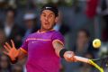 MADRID, SPAIN - MAY 13: Rafael Nadal of Spain returns a shot to Novak Djokovic of Serbia in their semi-final match ...