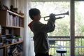 MELBOURNE, AUSTRALIA - MAY 14: Young boy Sidney practices the trumpet and piano at home in Fitzroy on May 14, 2017 in ...