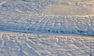 File - Winter sun setting over the tundra polygons in northern Alaska in November 2015. As winter sets in and snow settles, the soils take time to freeze completely and continue to emit carbon dioxide long into the new year.